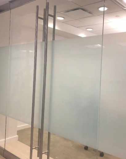 Frosted glass film installed on the glass doors of a conference room in a corporate office.